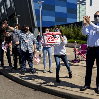 Raisbeck Aviation High School staffers cheer on seniors during graduation ceremonies Thursday, June 11, 2020. 214086