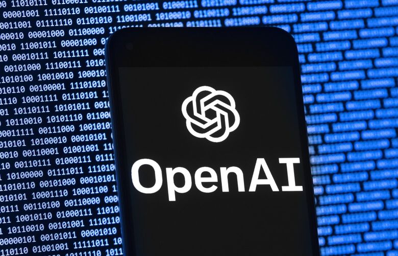 The OpenAI logo appears on a mobile phone in front of a computer screen with random binary data in 2023. (AP Photo/Michael Dwyer) 