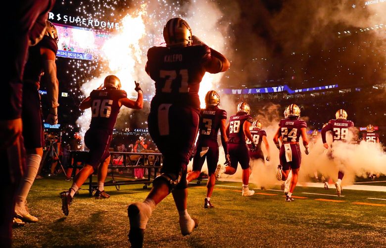 The Washington Huskies run out through the pyro before the start of the Sugar Bowl Monday, Jan. 1, 2024 in New Orleans. 225854
