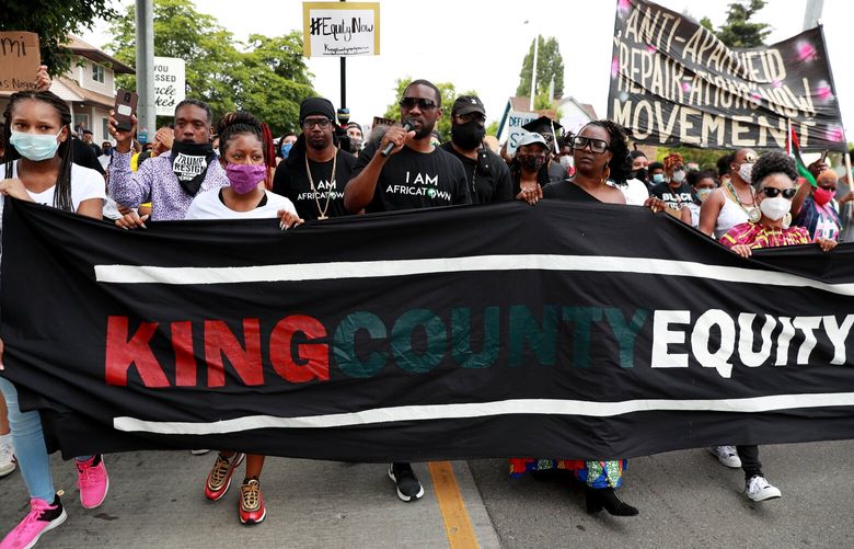 Africatown’s K. Wyking Garrett, center, leads marchers at the Juneteenth Freedom March & Celebration in Seattle Friday, June 19, 2020.  The event is hosted by King County Equity Now Coalition CQ, an alliance of Black-led community organizations. 214296
