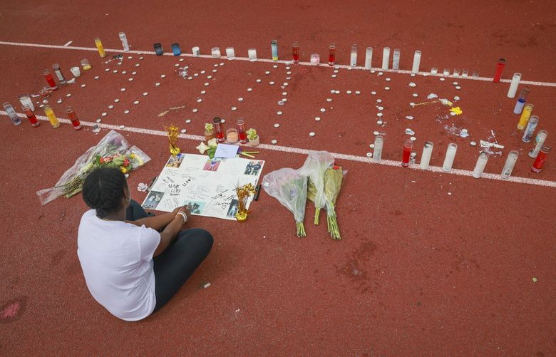 A little cousin of 17-year-old Amarr Murphy, who was a running back for the Bulldogs’ varsity football team, sits by a memorial for him at Garfield High’s track on Saturday, June 8, 2024. Murphy was shot and killed trying to break up a fight between two boys Thursday afternoon in front of the Quincy Jones Performance Center. 227164