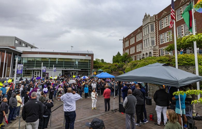 Parents and community members gather outside Garfield High School to listen to speakers and pray before the group welcomes students back, Tuesday, June 11, 2024 in Seattle. The school was closed Friday and Monday after the fatal shooting of student Amarr Murphy-Paine, 17.