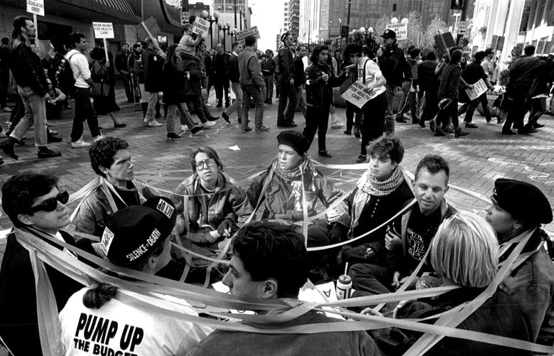 Members of Act up hold an impromtu sit-in in the intersection of Pine St
in downtown Seattle. Upset by the government’s lack of funding for AIDS, these protesters wrapped themselves in “red tape”.
( END)