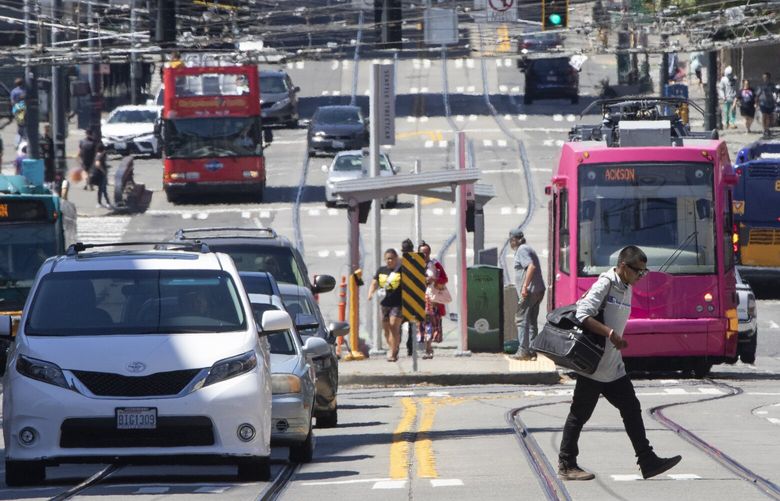 A man crosses S. Jackson St. at 6th Ave. S. In front of the Japantown streetcar station in Seattle Thursday, August 3, 2023.

 Seattleites exposure to heat has grown with increased concretization and diminishing green cover with greater impacts on vulnerable communities. 224626