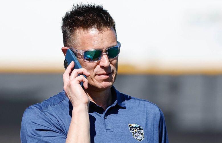 General Manager Jerry Dipoto works the phone while watching batting practice Thursday.  The Seattle Mariners conducted Spring Training drills Thursday, Feb. 22, 2024 at the Peoria Sports Complex, in Peoria, AZ. 226221