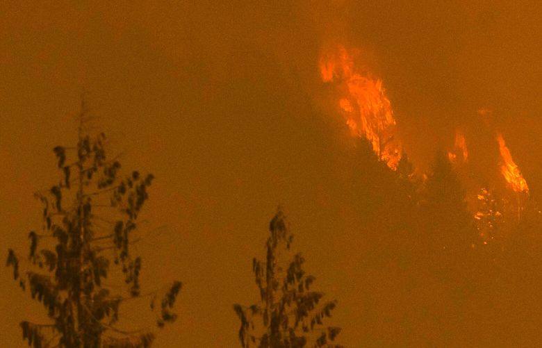 Bolt Creek Fire burns trees in the distance near Baring on Saturday on Sept. 10, 2022.