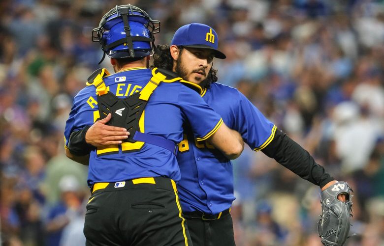 Cal Raleigh gives pitcher Andrés Muñoz a hug after a 2-1 win over Toronto, July 5, 2024, in Seattle. (Dean Rutz / The Seattle Times)