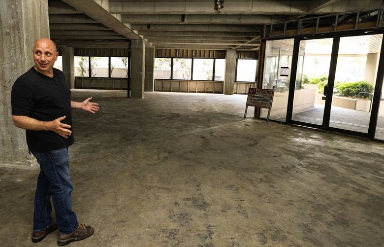 Marc Angelillo, a developer, gives a tour of an office building he plans to convert into apartments, near Climate Pledge Arena, Monday, July 8, 2024, in Seattle. Angelillo stands in what had been a small reception area surrounded by offices.