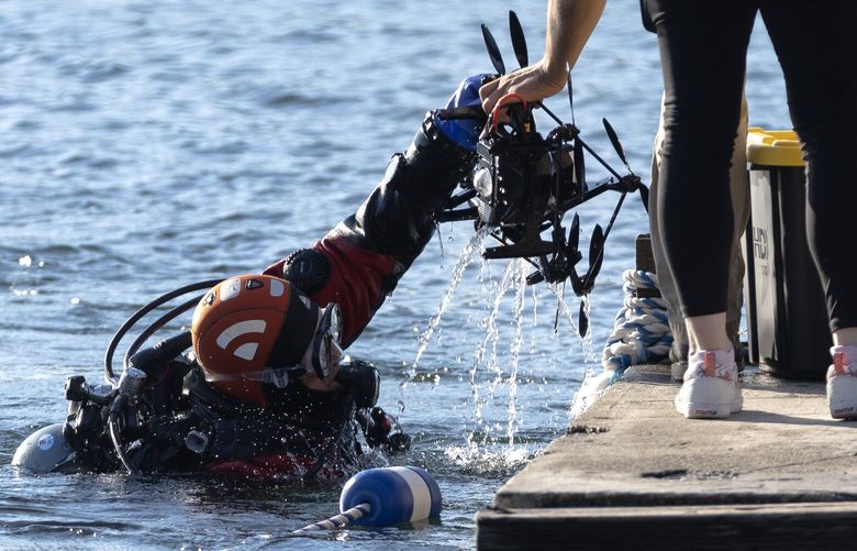 A diver recovers a drone from Angle Lake on Wednesday, July 10, 2024, in SeaTac. Fifty-five drones crashed into the lake during what was supposed to be a Fourth of July drone light show produced by the Great Lakes Drone Co.