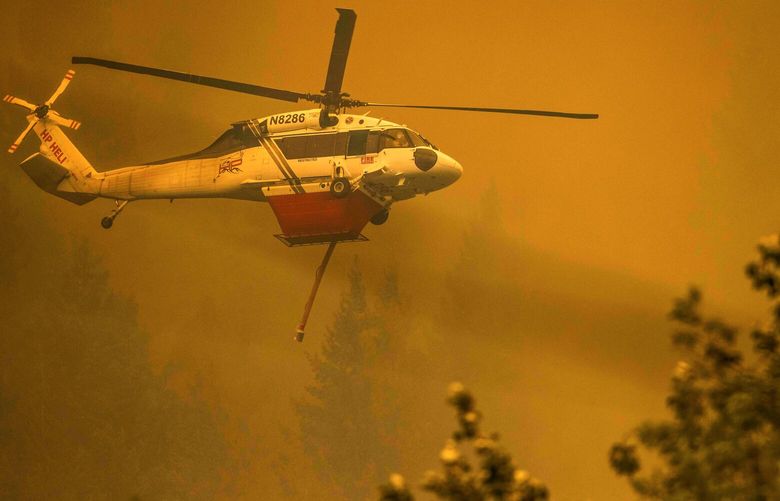 A helicopter provides air support for fighting the Bolt Creek Fire Saturday September 10, 2022