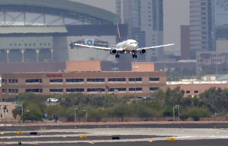 Heat waves ripple across the tarmac at Sky Harbor International Airport as downtown Phoenix stands in the background as an airplane lands, Tuesday, June 20, 2017 in Phoenix. The Phoenix City Council is mulling a vote to raise fees charged ride-hailing companies to $4 per trip to and from the airport. Council members Wednesday, Dec. 18, 2019 are to decide on the proposal to increase the current fee from $2.66 per pickup. (AP Photo/Matt York)