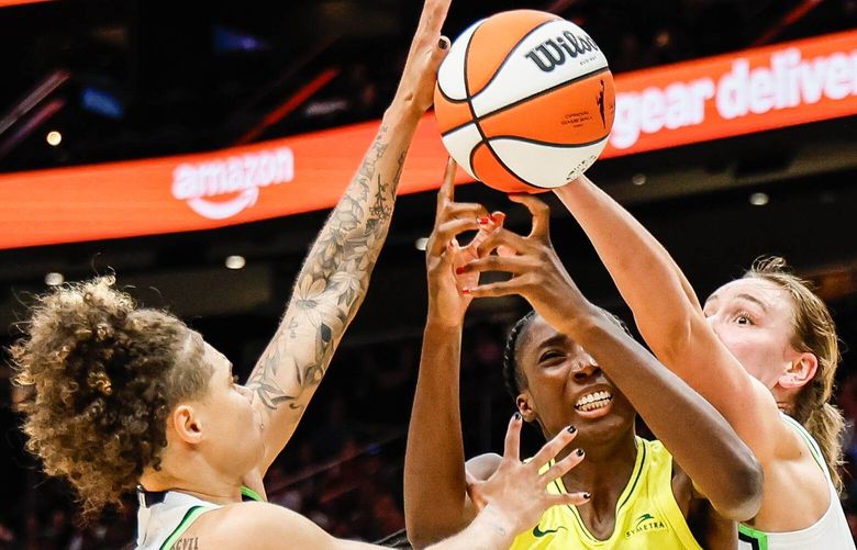 Seattle’s Ezi Magbegor is fouled on the offensive rebound double-teamed by Minnesota’s Natisha Hiedeman, left, and Bridget Carleton in the second quarter, Friday, July 12, 2024 at Climate Pledge Arena, in Seattle.