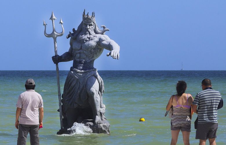 Tourists take pictures of Poseidon sculpture before the arrival of Hurricane Beryl in Progreso, Mexico, Thursday, July 4, 2024. (AP Photo/Martin Zetina) OTKMXEV117