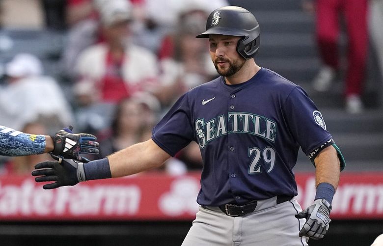 Seattle Mariners’ Cal Raleigh, center, is congratulated by Julio Rodriguez, left, after hitting a two-run home run as Los Angeles Angels catcher Logan O’Hoppe kneels at the plate during the third inning of a baseball game Friday, July 12, 2024, in Anaheim, Calif. (AP Photo/Mark J. Terrill) ANS120 ANS120