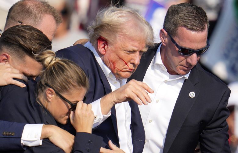 Republican presidential candidate former President Donald Trump is helped off the stage at a campaign event in Butler, Pa., on Saturday, July 13, 2024. (AP Photo/Gene J. Puskar) PAGP116 PAGP116