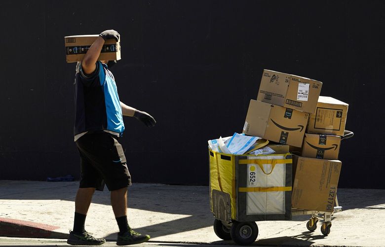 An Amazon worker delivers packages in Los Angeles on Oct. 1, 2020. July sales events have become a seasonal revenue driver for the retail industry since Amazon launched its first Prime Day back in 2015. (AP Photo/Damian Dovarganes) 