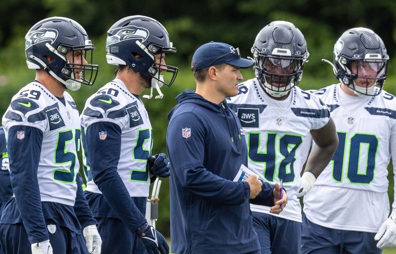 Mike Macdonald, center, in the midst of players during, OTAs, organized team activities Wednesday afternoon at the Virginia Mason Athletic Center in Renton, Washington, on May 22, 2024. 226938
