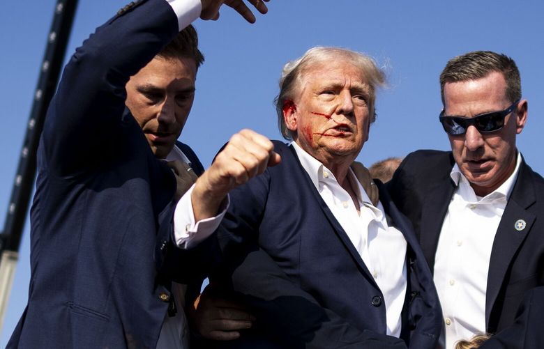 Secret Service agents lead former President Donald Trump, bloodied by the bullet wound to his ear, offstage after an attempted assassination during a campaign rally in Butler, Pa., July, 13, 2024. The political violence – the first time in more than four decades that a man who was elected president of the U.S. was wounded in an assassination attempt – comes at an especially volatile moment in American History. (Doug Mills/The New York Times) XNYT0868 XNYT0868