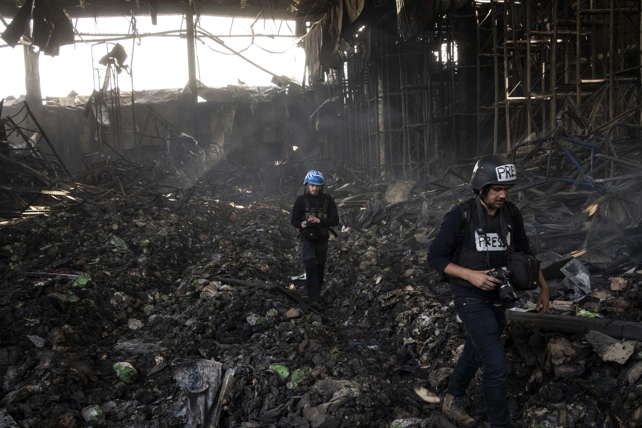  Journalists walk inside a destroyed warehouse for storing food, after an attack from Russia twelve days ago in Brovary, on the outskirts of Kyiv, Ukraine, Tuesday, March 29, 2022. (AP Photo/Rodrigo Abd) 