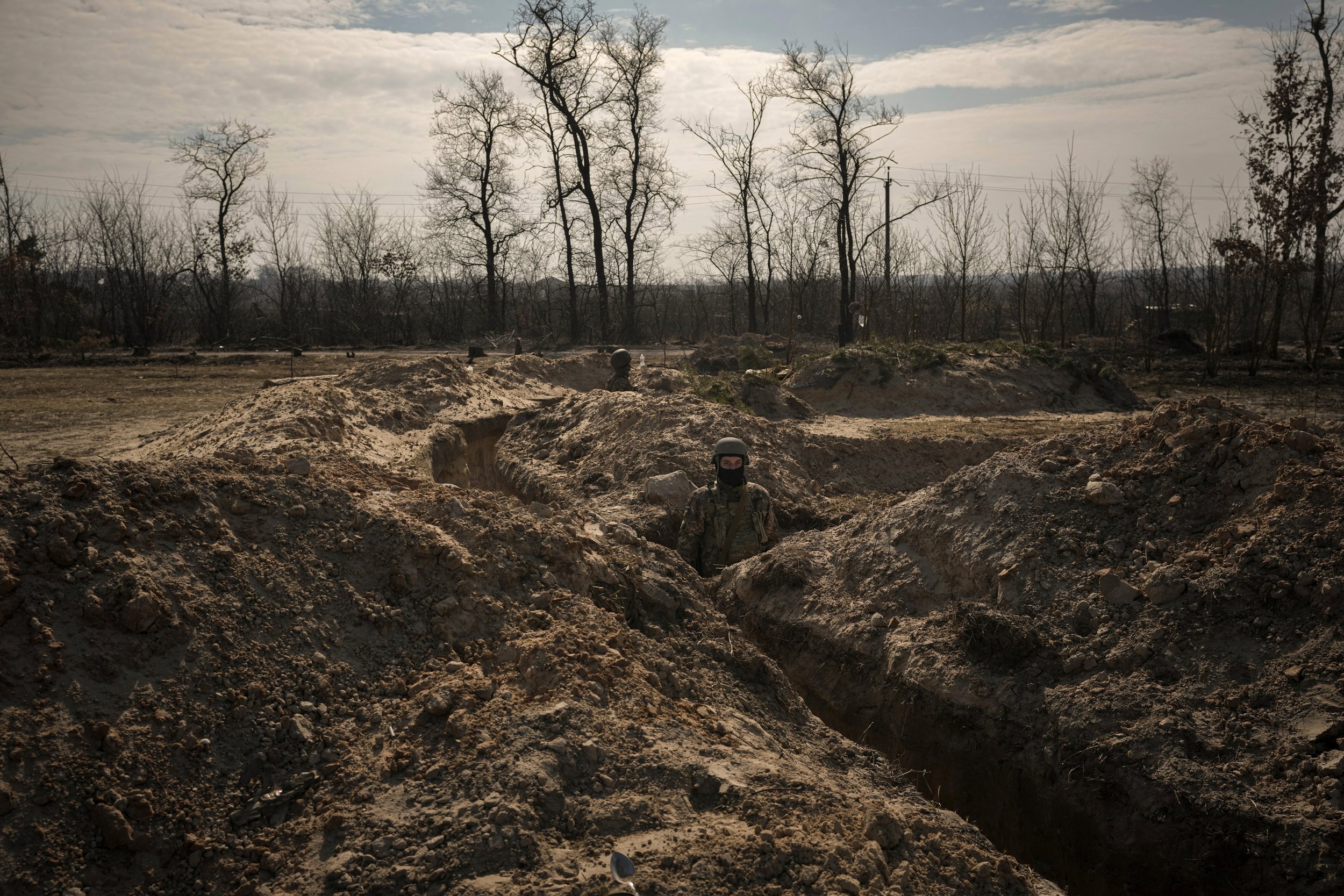  Ukrainian servicemen stand in trenches at a position north of the capital Kyiv, Ukraine, Tuesday, March 29, 2022. (AP Photo/Vadim Ghirda) 