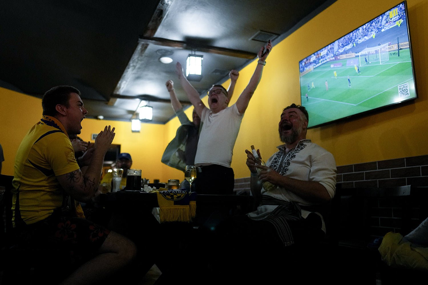  Fans celebrate Ukraine's Andriy Yarmolenko scoring the team's opening goal at a World Cup 2022 qualifying play-off soccer match against Scotland, at a bar in Kyiv, Ukraine, Wednesday, June 1, 2022. (AP Photo/Natacha Pisarenko) 