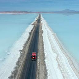 Roter Lastwagen fährt über Lithiumfeld in Bolivien