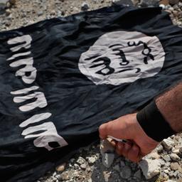 Ein Mann zündet eine Flagge des IS an