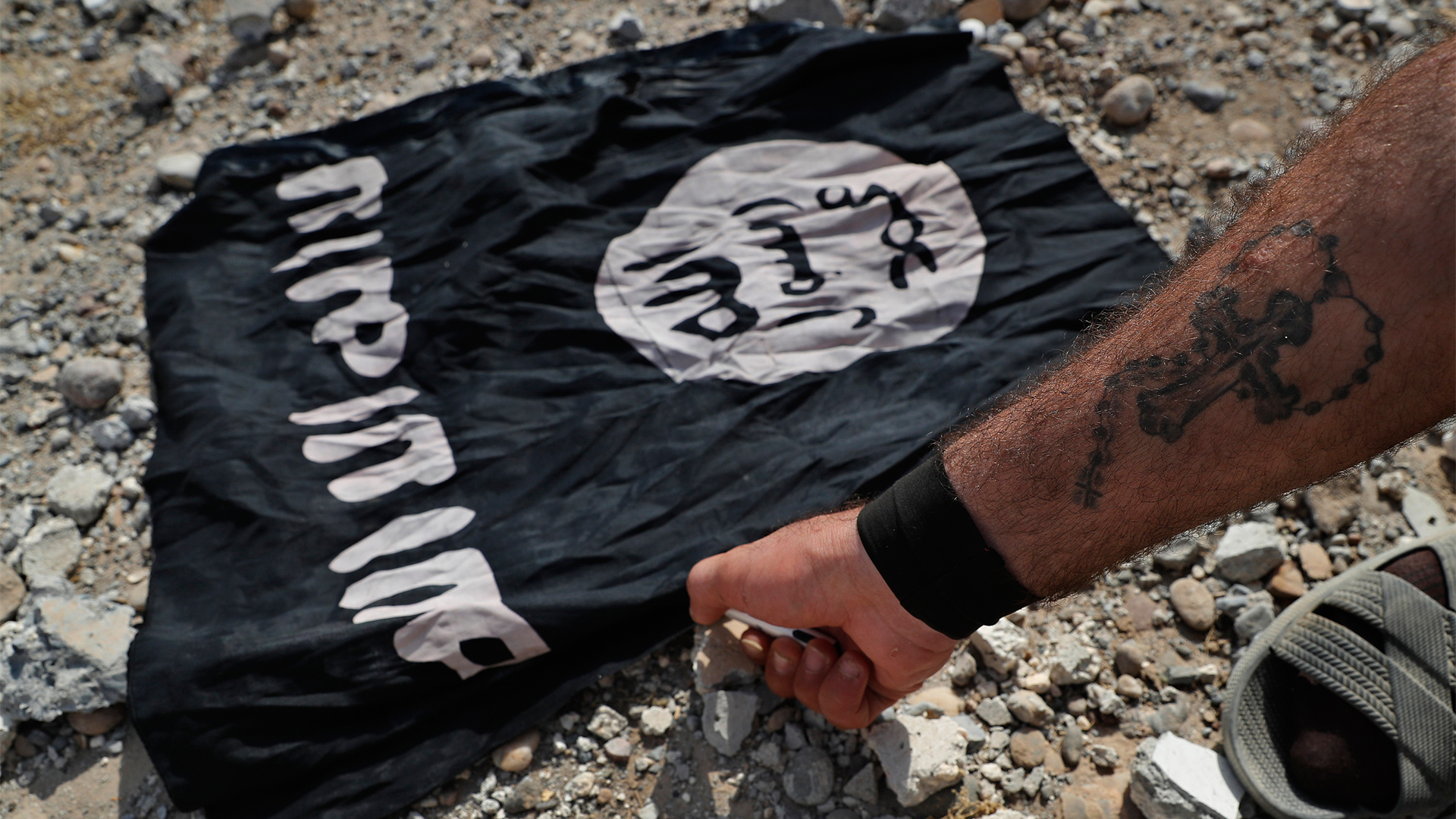 Ein Mann zündet eine Flagge des IS an