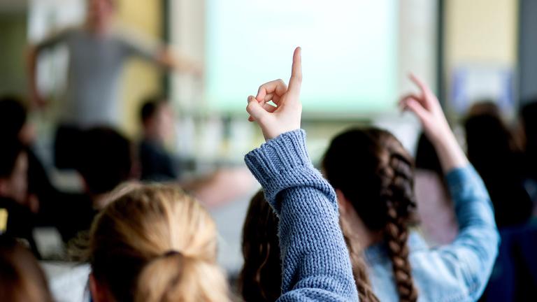 Schülerinnen melden sich während des Unterrichts an einer Schule.