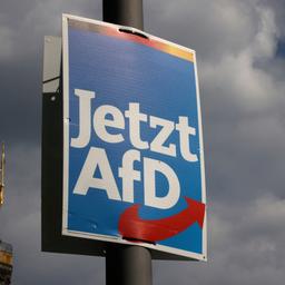 Ein AfD-Wahlplakat ist vor einem dunklen Wolkenhimmel in Berlin zu sehen.