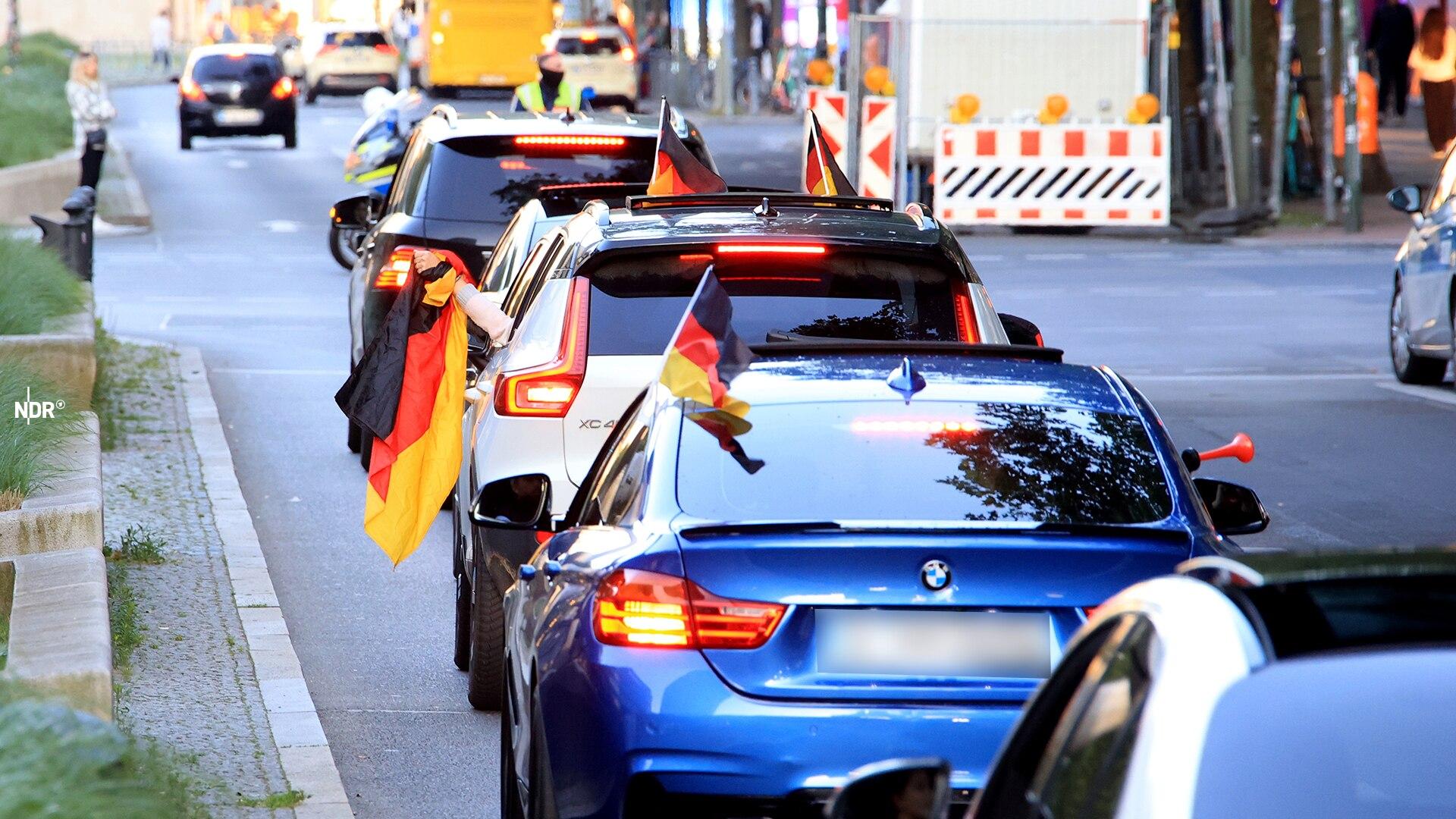 Fußballfans nehmen an einem Autokorso teil.