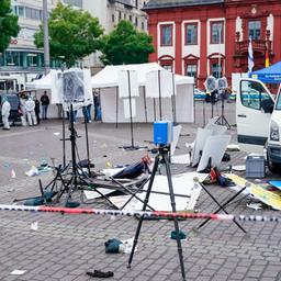 Mitarbeiter der Spurensicherung stehen auf dem Marktplatz hinter einem zertrümmerten Stand in Mannheim