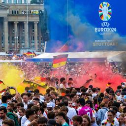 Deutschland-Fans zünden beim Public Viewing auf dem Stuttgarter Schlossplatz Pyrotechnik in den deutschen Nationalfarben.