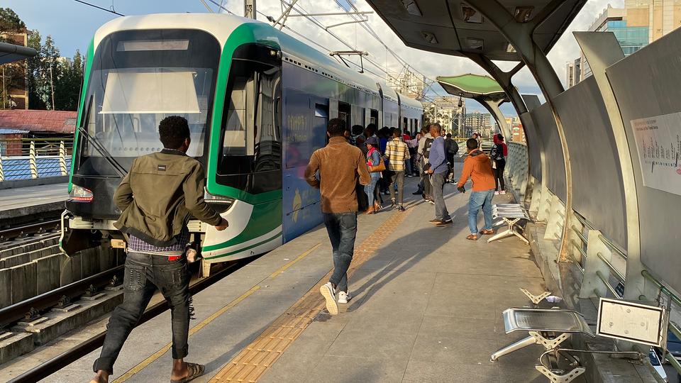 Passanten steigen in der Innenstadt von Äthiopiens Hauptstadt Addis Abeba in eine Straßenbahn ein.