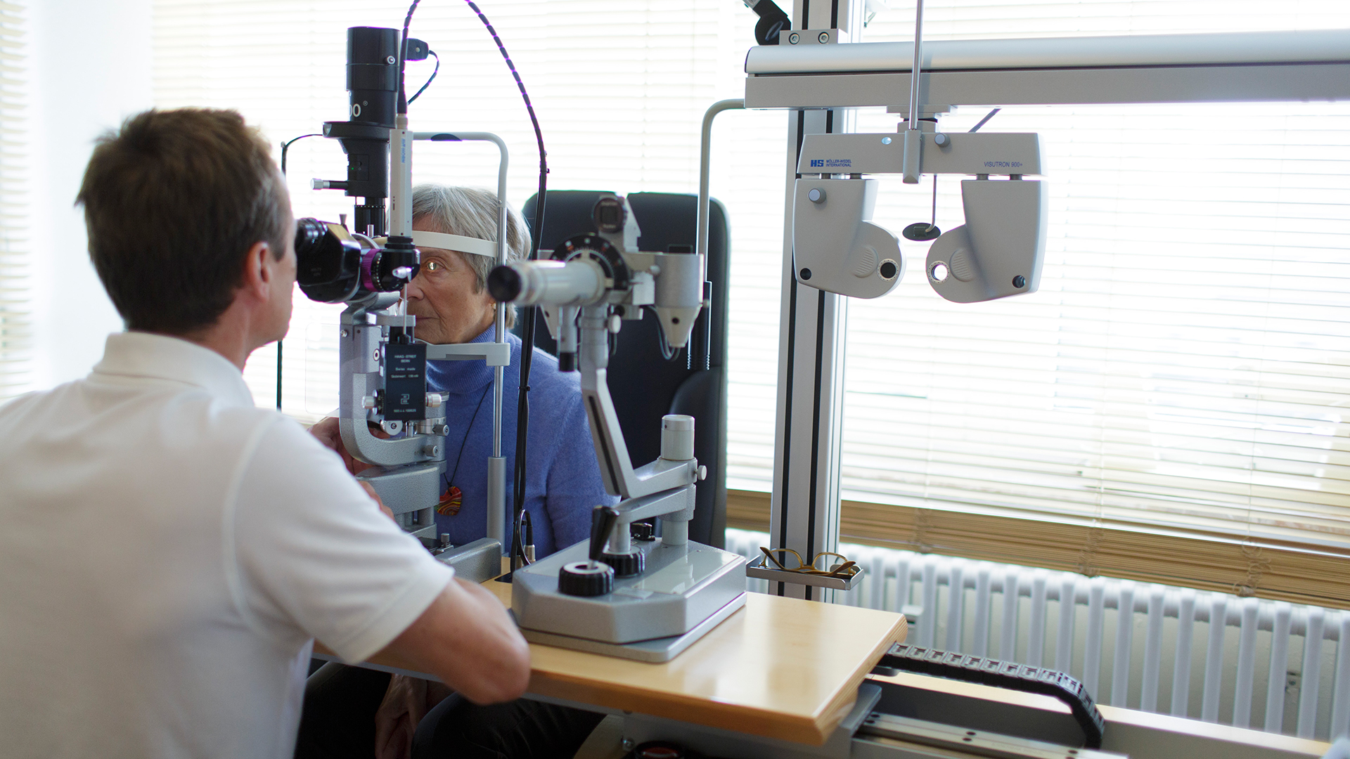 Ein Augenarzt untersucht eine Patientin.