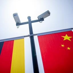 Die chinesische und die deutsche Flagge unter zwei Überwachungskameras