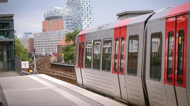 U-Bahn an der Station Landungsbrücken in Hamburg - im Hintergrund die Elbphilharmonie