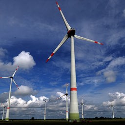  Windkraftanlagen sind vor bewölktem Himmel zu sehen. 