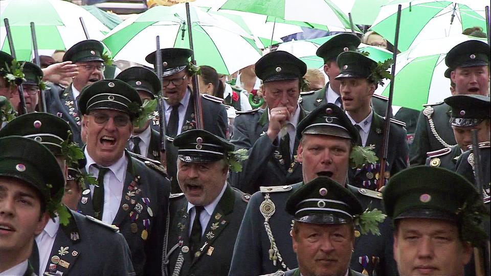 Zahlreiche Menschen nehmen bei Regenwetter am Schützenausmarsch in Hannover teil.