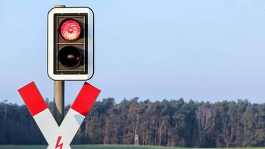 Rote Ampel und Andreaskreuz an einem Bahnübergang (Themenbild)