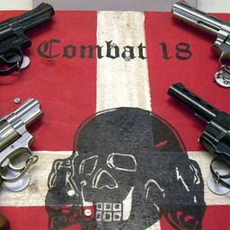 Waffen und ein sichergestelltes Schild der Neonazi Gruppierung ''Combat 18''
