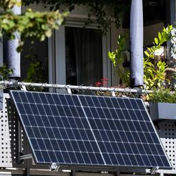 Eine kleine Solaranlage ist an einem Balkon eines Mehrparteienhauses angebracht.