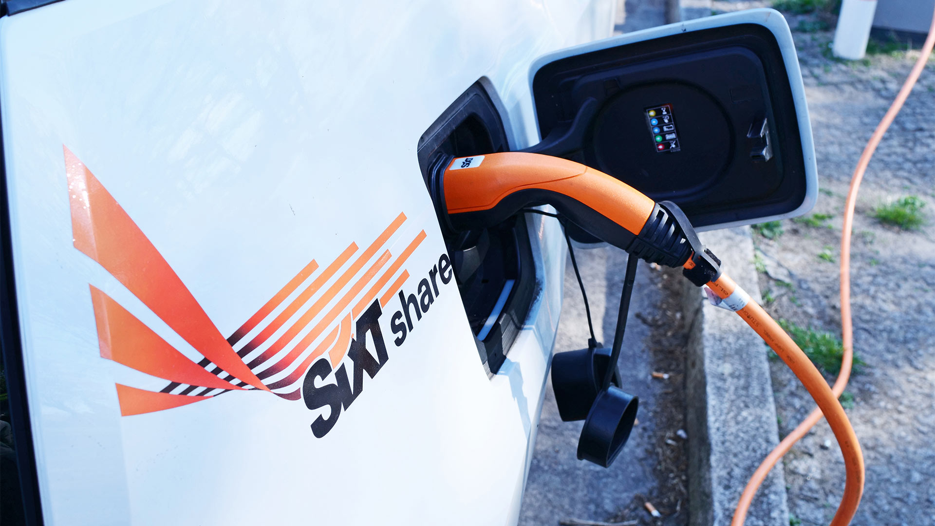 Ein E-Fahrzeug mit dem aufgeklebten Logo von Sixt Share, dem Carsharing-Angebot des Autovermieters