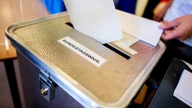 Ein Wähler wirft in einem Berliner Wahllokal seinen Stimmzettel für die Bundestagswahl in eine Wahlurne.