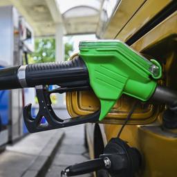 Eine Zapfpistole steckt an einer Tankstelle im Einfüllstutzen eines Pkw.