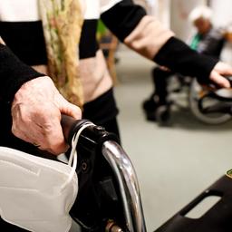 Eine Heimbewohnerin schiebt ihren Rollator durch einen Gang in einem Pflegeheim.