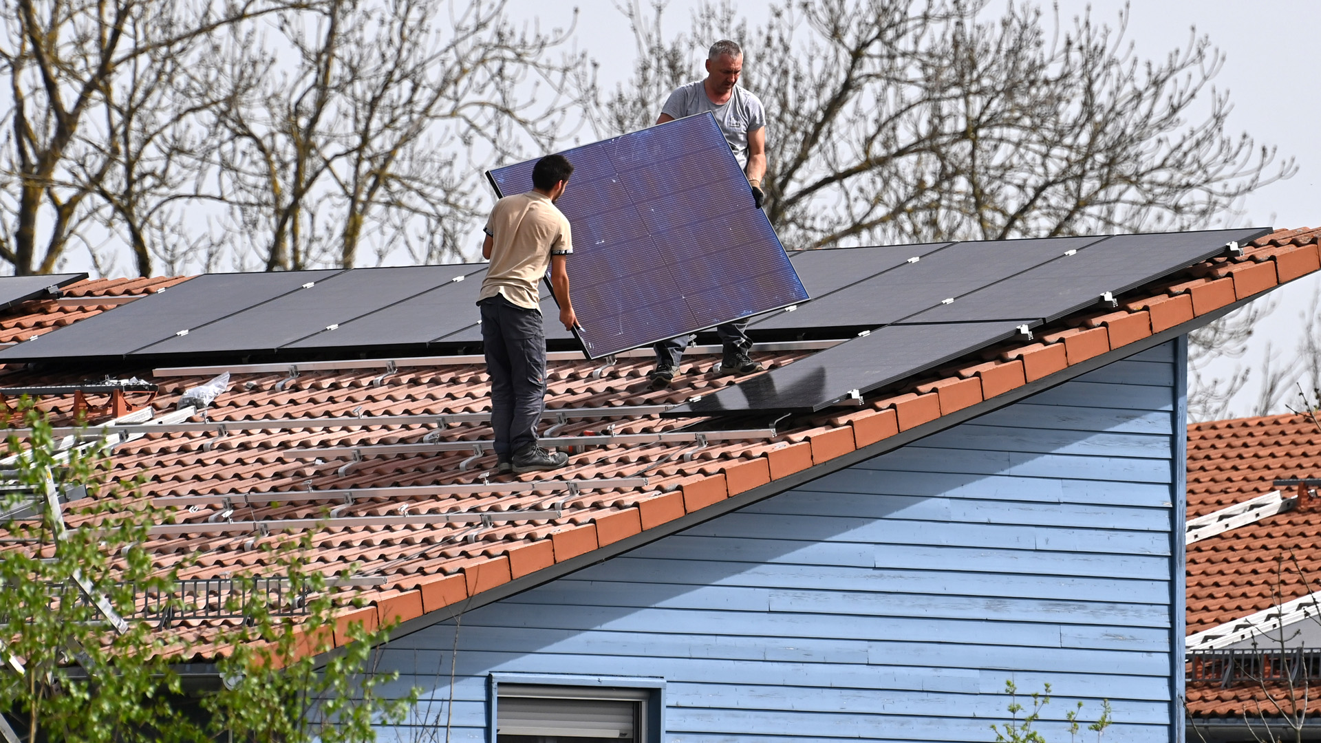 Montage von Solarpaneelen auf einem Hausdach.