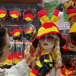 Eine Schaufensterpuppe mit großem Hut und verschiedene Artikel in den Nationalfarben Deutschlands