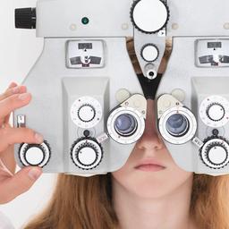 Ein Kind hinter einem Optometrist in einer Augenarztpraxis