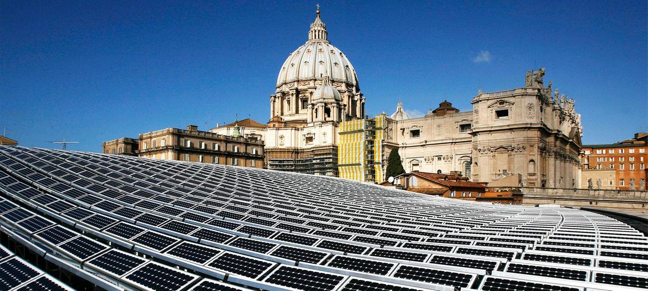 Solaranlage auf dem Dach des Vatikans, mit dem Petersdom im Hintergrund.